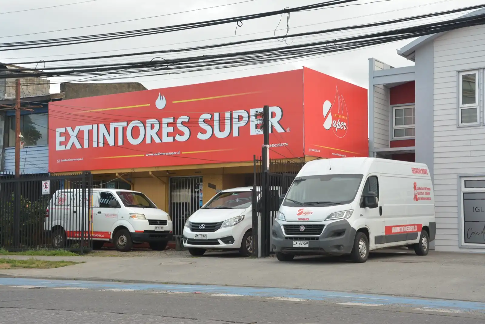 Frontis de Extintores Súper en San Martín 0118, Temuco, con tres vehículos de la empresa estacionados